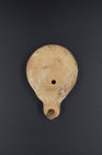 A ROMAN TERRACOTTA OIL LAMP WITH DECORATED DISCUS